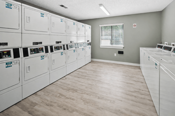 Shared laundry room with multiple washers and dryers
